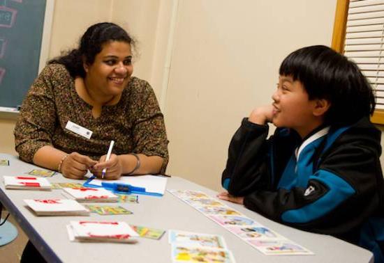 person sits at low table with child in study